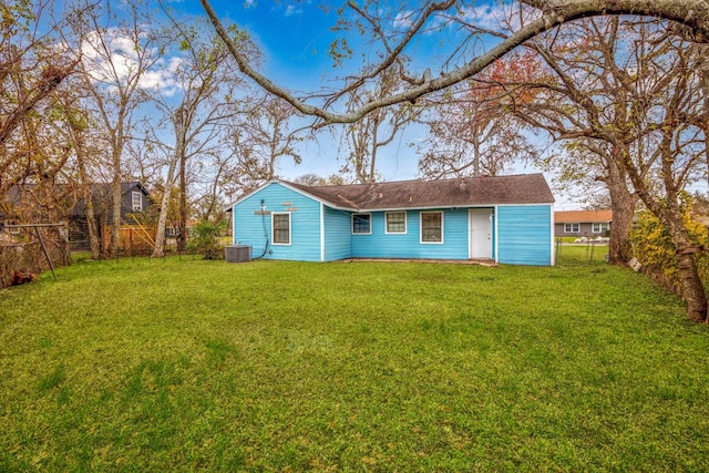 back of property featuring a lawn and central AC