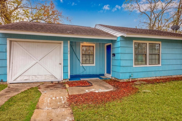 view of front of property with a garage and a front lawn