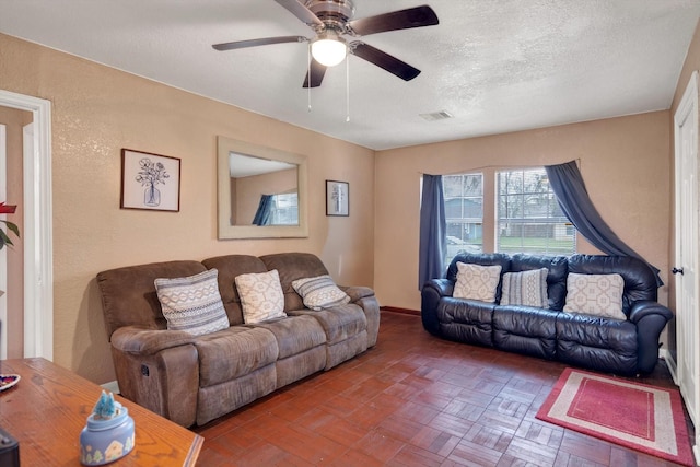 living room with a textured ceiling and ceiling fan