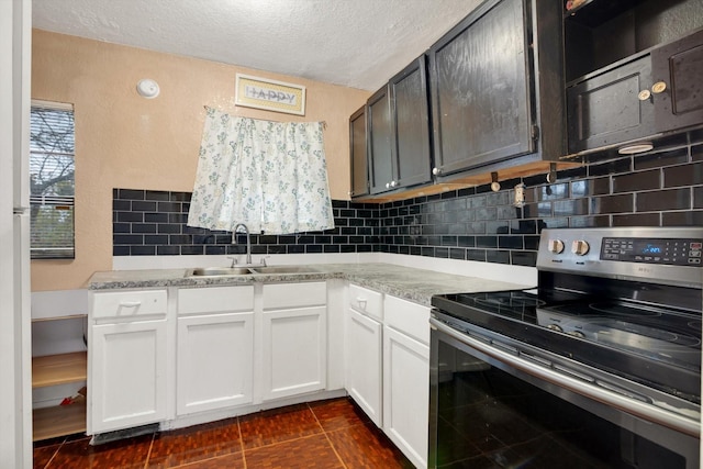 kitchen featuring light stone countertops, a textured ceiling, white cabinetry, stainless steel range with electric stovetop, and sink