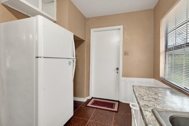 kitchen featuring white fridge and dark tile patterned floors