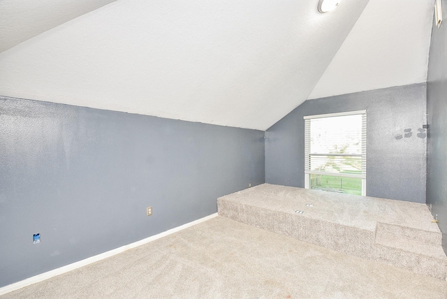 bonus room with lofted ceiling, a textured ceiling, and carpet flooring