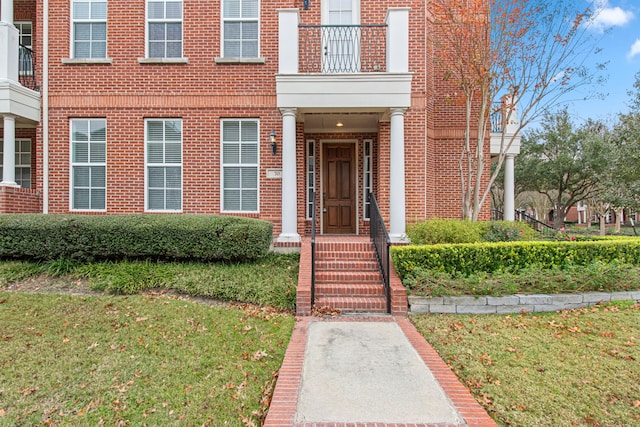 doorway to property featuring a lawn