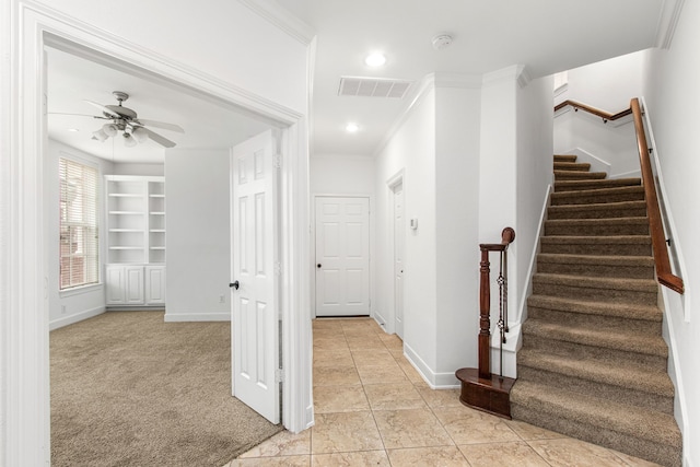 staircase featuring carpet flooring, ceiling fan, and ornamental molding