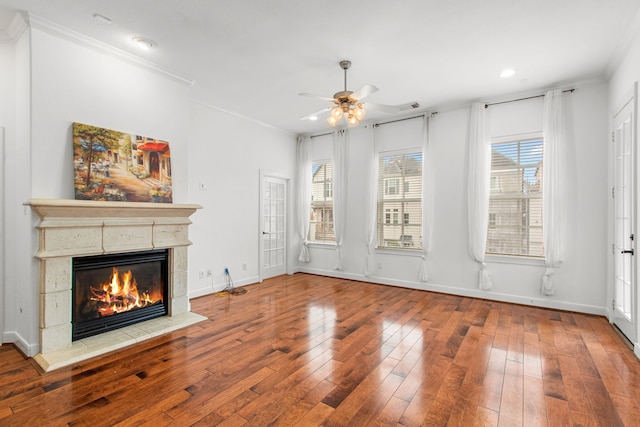 unfurnished living room with hardwood / wood-style floors, a fireplace, ornamental molding, and plenty of natural light