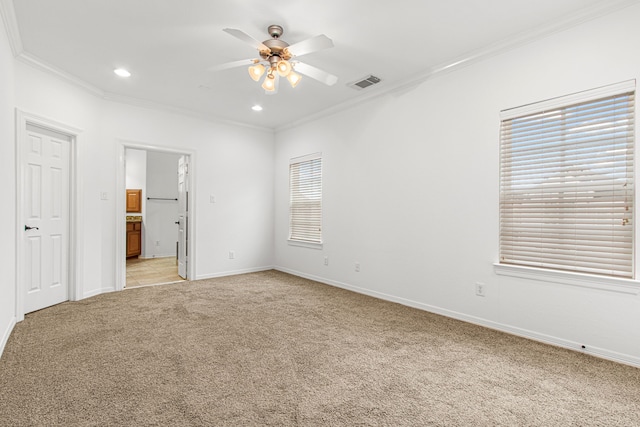 unfurnished bedroom featuring ceiling fan, ornamental molding, ensuite bath, and light carpet