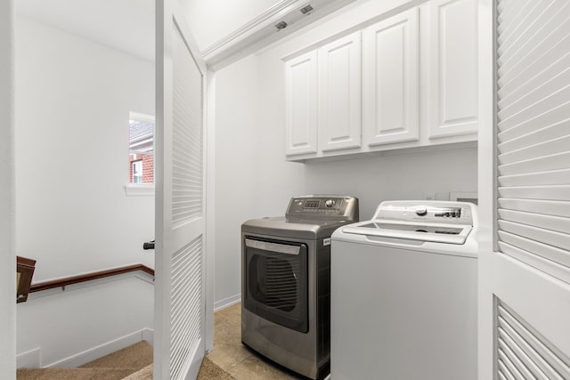 laundry room featuring washer and dryer and cabinets