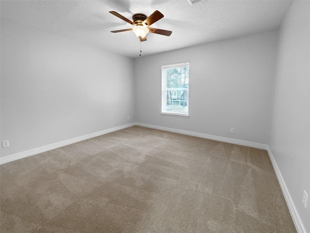 carpeted empty room featuring ceiling fan and a textured ceiling