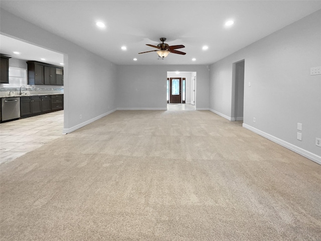 carpeted spare room with ceiling fan and sink