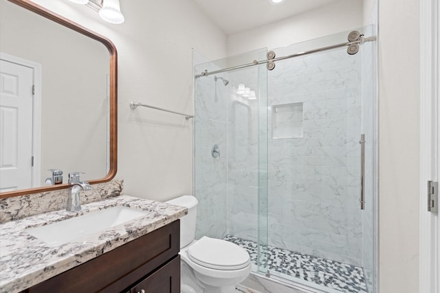 bathroom with walk in shower, vanity, and toilet