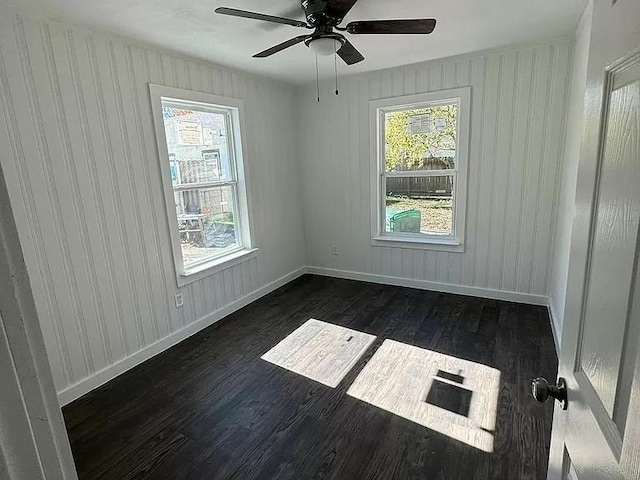 spare room with dark hardwood / wood-style flooring and ceiling fan