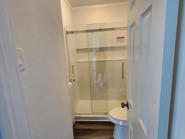 bathroom with toilet, hardwood / wood-style flooring, and walk in shower