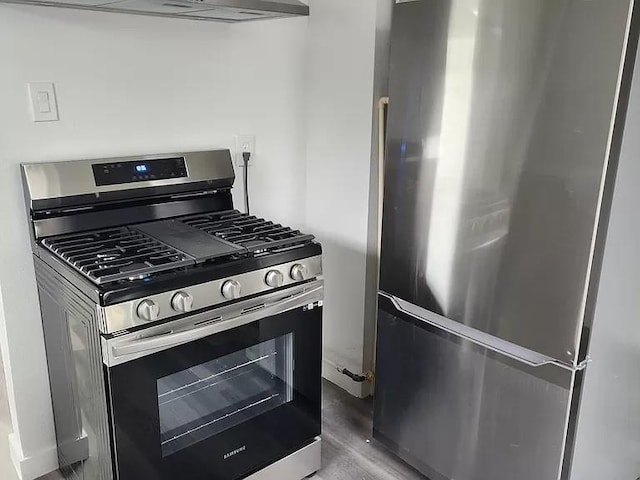 kitchen featuring range hood, appliances with stainless steel finishes, and wood-type flooring