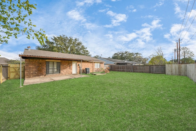 rear view of house with a patio area, a yard, and central AC