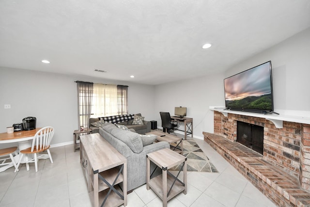 living room with a brick fireplace and light tile patterned floors