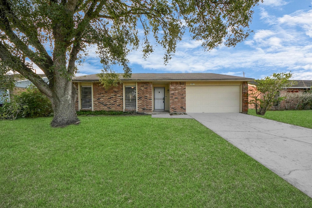 ranch-style home with a front lawn and a garage