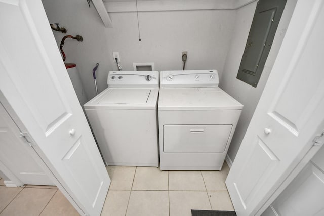 laundry room with washing machine and dryer, light tile patterned floors, and electric panel