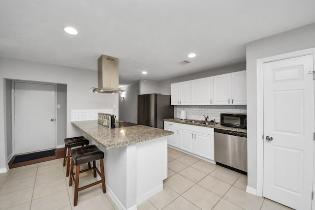 kitchen with tasteful backsplash, sink, appliances with stainless steel finishes, white cabinets, and island range hood