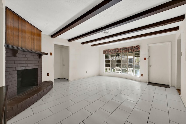 unfurnished living room with a brick fireplace, light tile patterned floors, and beamed ceiling