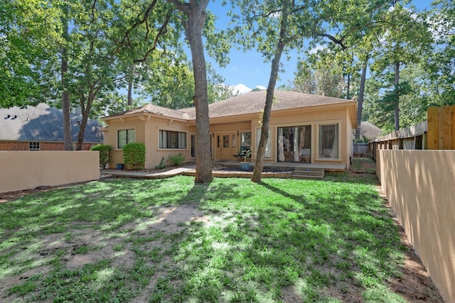 back of house featuring a lawn