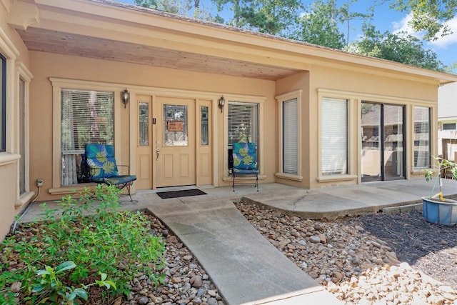 view of exterior entry with a patio