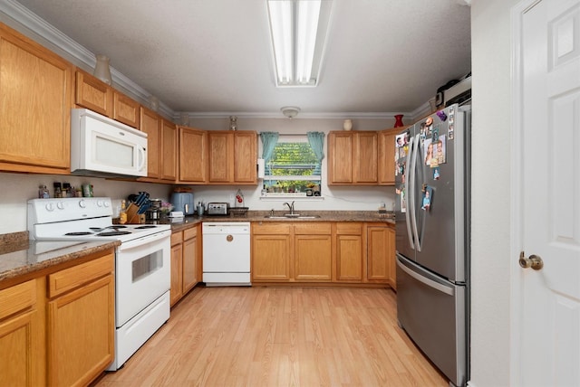 kitchen with white appliances, light stone counters, crown molding, and sink