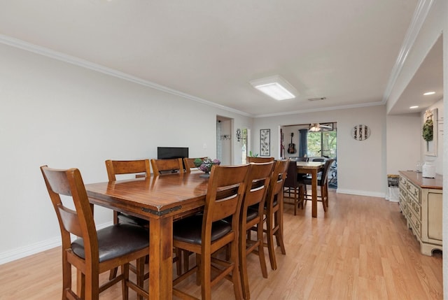 dining room featuring crown molding and light hardwood / wood-style flooring