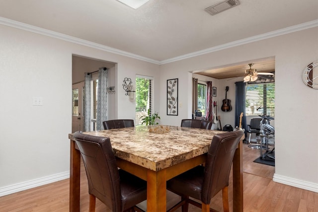 dining area with ceiling fan, light wood-type flooring, and crown molding