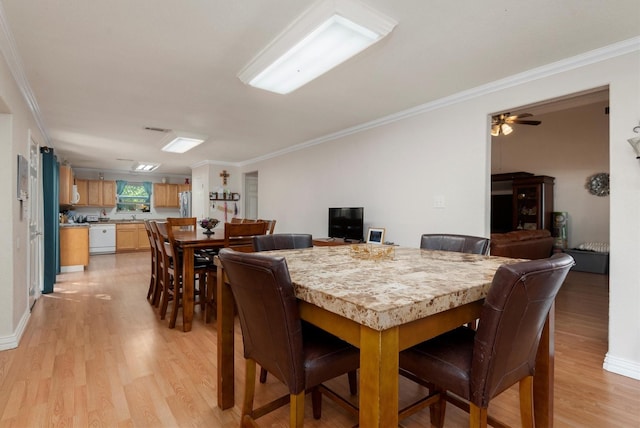 dining room with ornamental molding, ceiling fan, and light hardwood / wood-style flooring