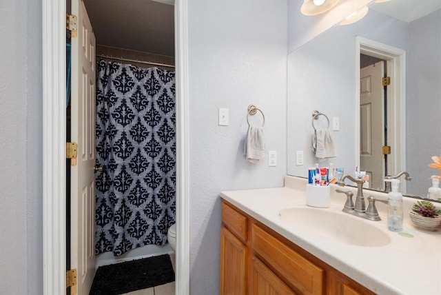 bathroom featuring curtained shower, vanity, and toilet