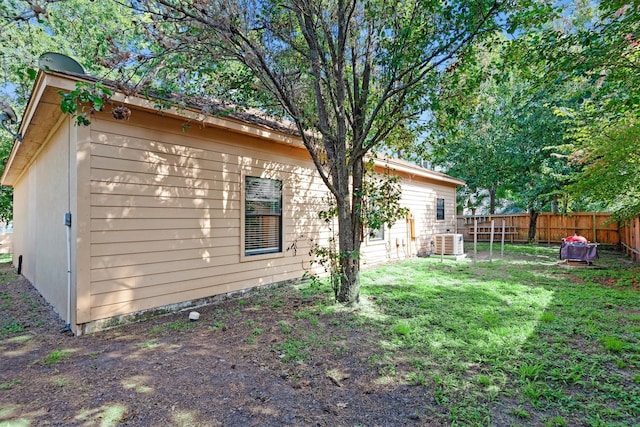 view of home's exterior featuring cooling unit and a lawn