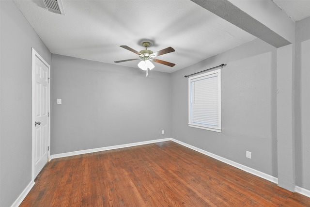 empty room with ceiling fan and dark hardwood / wood-style floors