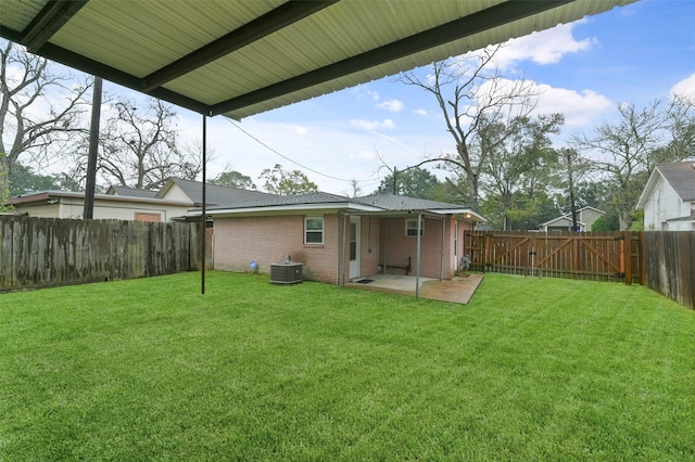 rear view of house with a yard, central AC unit, and a patio