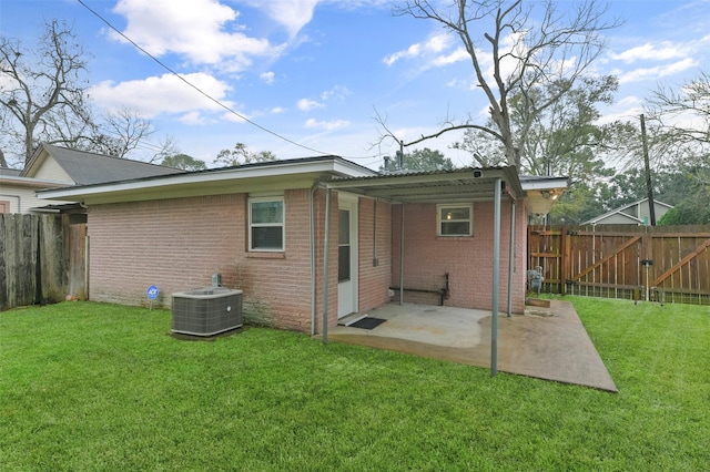 rear view of house featuring a yard, central AC, and a patio area