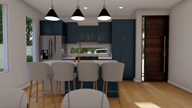 kitchen with pendant lighting, stainless steel fridge, light wood-type flooring, and blue cabinets