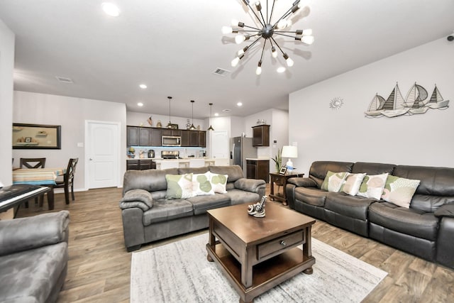 living room with an inviting chandelier and hardwood / wood-style flooring