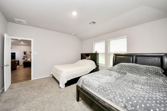 bedroom with vaulted ceiling and light carpet