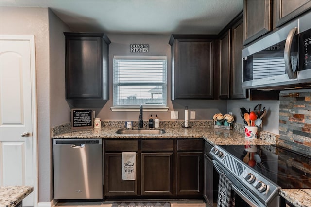 kitchen featuring sink, dark brown cabinetry, light stone countertops, and stainless steel appliances