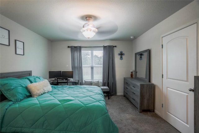 bedroom with ceiling fan, light colored carpet, and a textured ceiling