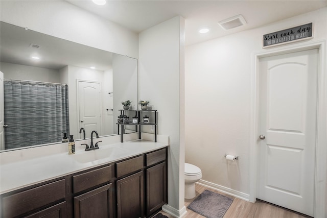 bathroom featuring vanity, hardwood / wood-style flooring, and toilet