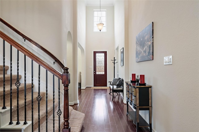 foyer with a towering ceiling and dark hardwood / wood-style floors