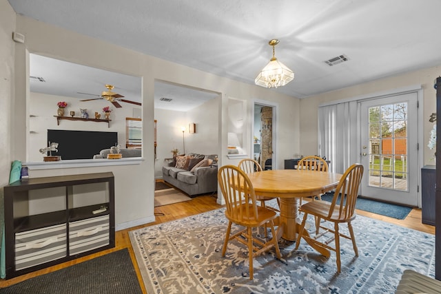 dining area with ceiling fan and wood-type flooring