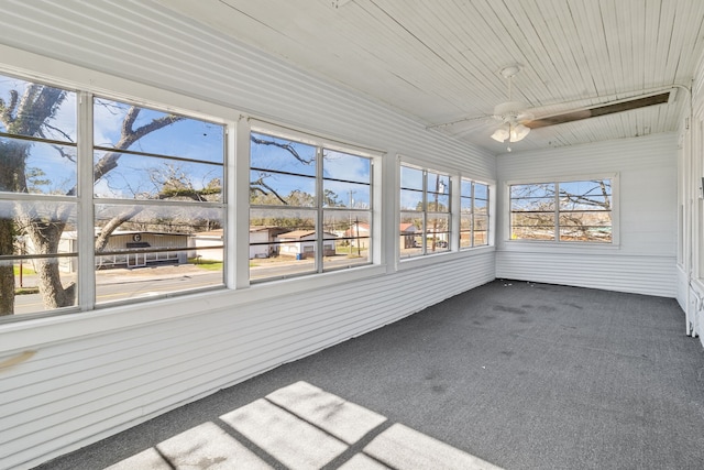 unfurnished sunroom with wood ceiling, ceiling fan, and a healthy amount of sunlight