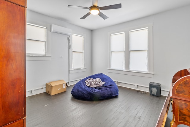 sitting room featuring a wall unit AC, dark hardwood / wood-style flooring, and ceiling fan