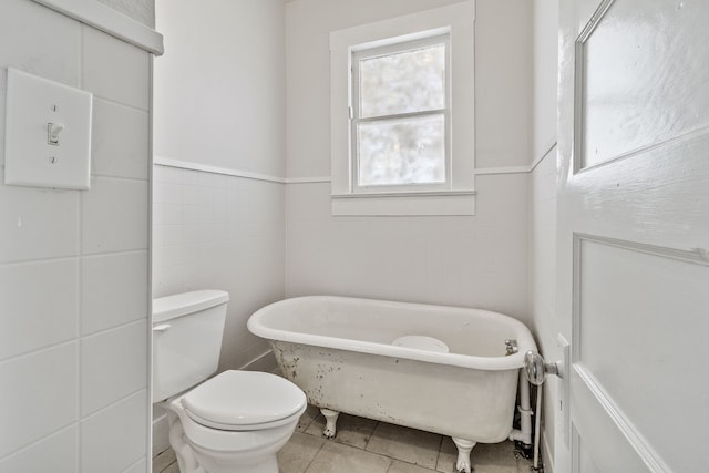 bathroom with a bathtub, tile patterned floors, and toilet