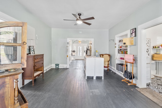 interior space with ceiling fan, a wealth of natural light, built in features, and dark hardwood / wood-style floors