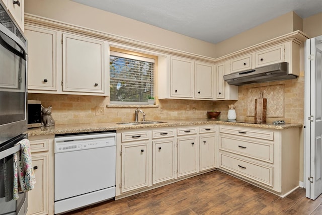 kitchen with sink, tasteful backsplash, dishwasher, and cream cabinets