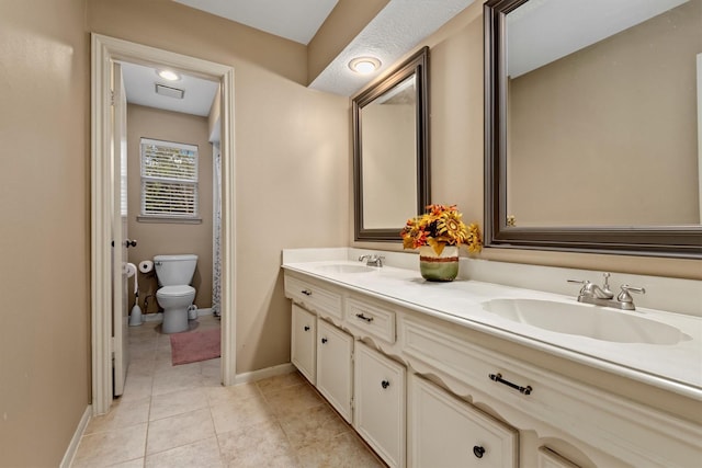 bathroom with toilet, a textured ceiling, tile patterned floors, and vanity