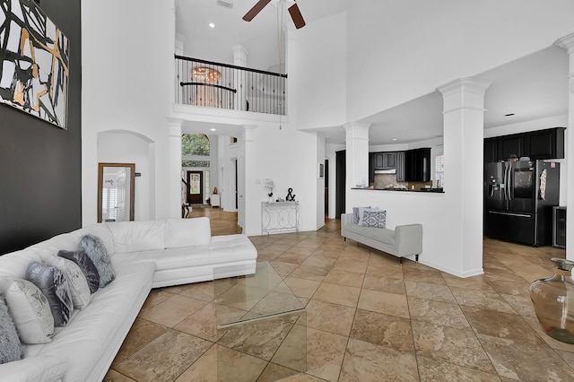 living room with decorative columns and ceiling fan