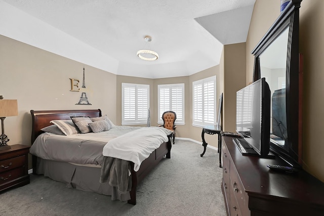 bedroom featuring light colored carpet and a raised ceiling